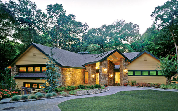 stylish green house plan with stone walkway and driveway