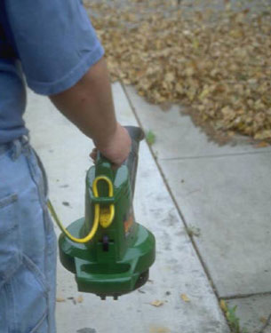 man blowing fall leaves